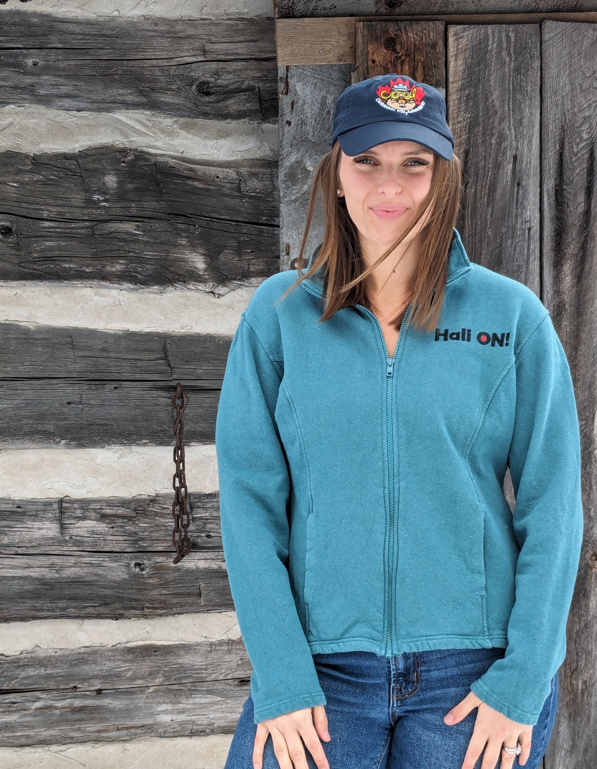 Our model Morgan wearing teal track jacket with HALI ON! embroidered on upper left chest: 'HALI ON!' is another original design from Small Town Natural. This design is a tribute to the small town of Haliburton, Ontario, Canada. Each jacket includes a removable zipper pull made of Pewter hand made in the small town of Tweed, Ontario. 55% Hemp 45% Organic Cotton – Fleece