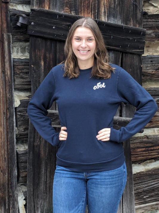 Cool with cyclist in graphic, embroidered in ice blue thread, on Navy slim fit crew neck sweatshirt Small Town Natural model Morgan is wearing a Unisex size Small. She typically wears a size Medium in Women's sweatshirts.