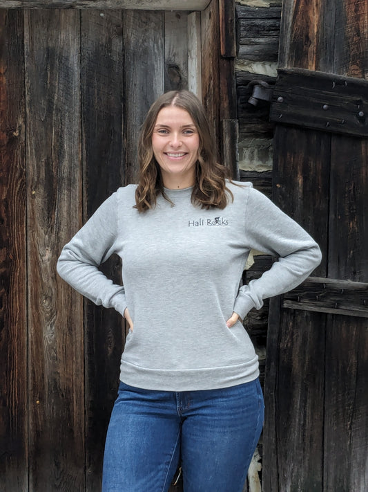 Hali Rocks with cyclist in graphic, embroidered in black on heather grey crew neck. Small Town Natural model Morgan is wearing a Unisex size Small. She typically wears a size Medium in Women's sweatshirts.