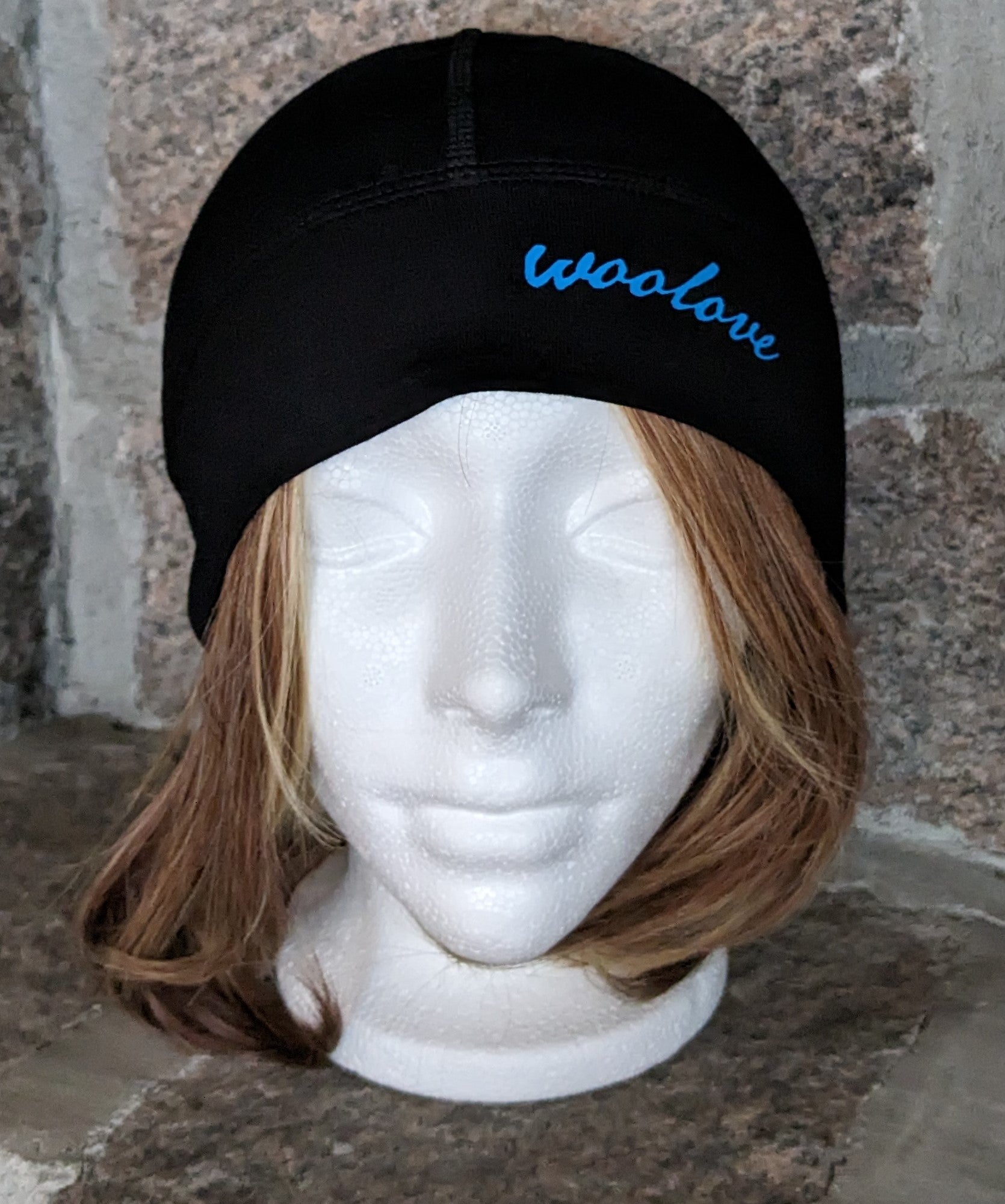 Hat Beanie Merino Wool by Wool Love great under a cycling helmet for warmth and moisture wicking it is black  with blue 'woolove' text logo